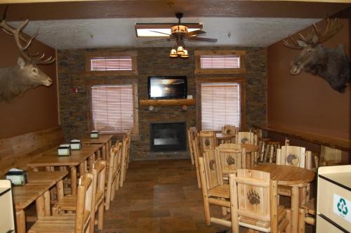 a dining room with tables and chairs and a fireplace at Kelly Inn West Yellowstone in West Yellowstone