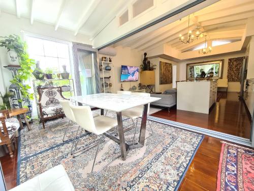 a living room with a white table and chairs at Bamboo House, Close to the City & Airport & Train station and Brighton Le Sands Beach in Sydney