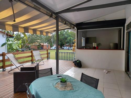 eine Terrasse mit einem Tisch und Stühlen auf einer Terrasse in der Unterkunft Les Gîtes de Fond Bellemare in Case-Pilote