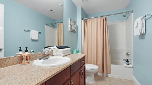 a bathroom with a sink and a toilet and a shower at Laketown Wharf #113 by Nautical Properties in Panama City Beach