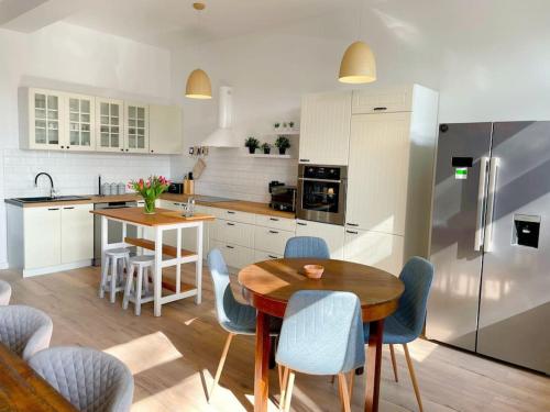 eine Küche mit einem Tisch und Stühlen sowie einem Kühlschrank in der Unterkunft Landhof in Ganschendorf, Landhaus Seenah in Sarow