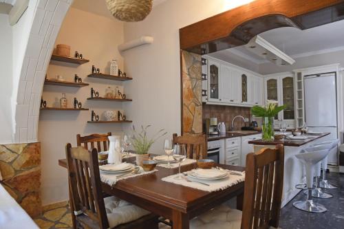 Calma House في Kompítsion: غرفة طعام مع طاولة وكراسي خشبية