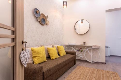 - un salon avec un canapé marron et des oreillers jaunes dans l'établissement Goldcentral Apartment Comfort, à Budapest