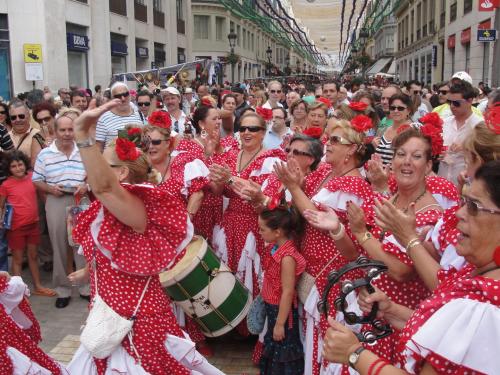 a crowd of people dressed in red polka dots on a street at Hotel Romerito in Málaga