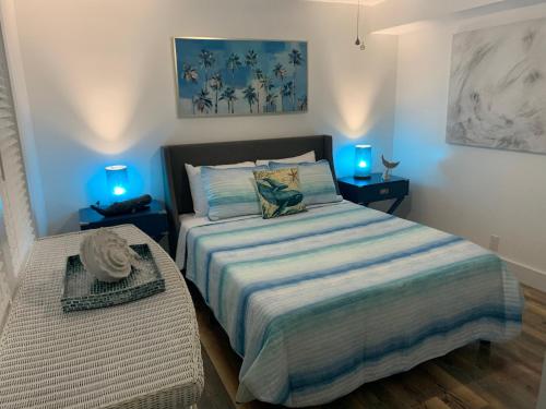 - une chambre avec un lit et 2 tables de nuit avec des lumières bleues dans l'établissement Oasis in Ocean Ridge, Walk to the Beach, à Boynton Beach