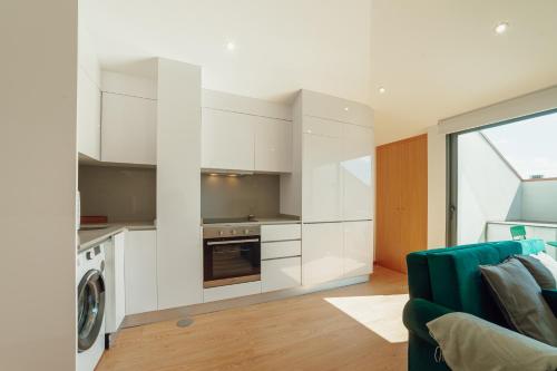 a kitchen with white cabinets and a washing machine at Modern & Stylish Apartments by Vacationy in Porto