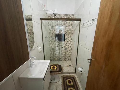 uma pequena casa de banho com um chuveiro e um lavatório. em Casa grande com Piscina e Churrasqueira em Bonito