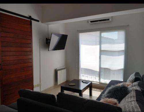 sala de estar con sofá y ventana grande en Departamento Canela en Salta