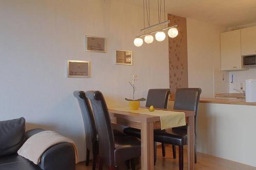 einen Esstisch mit Stühlen und eine Küche in der Unterkunft Harz-Idylle mit Sauna & Pool: Entspannung pur. in Braunlage