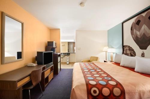 a hotel room with a large bed and a desk at Super 8 by Wyndham Indio in Indio