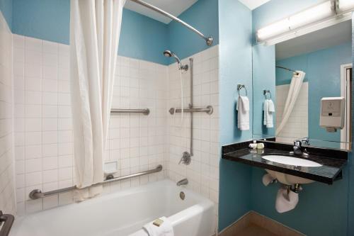 a bathroom with a white tub and a sink at Super 8 by Wyndham Indio in Indio