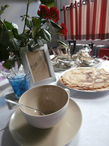 a table with plates of food and a bowl on a table at Chambres et Table d'hôtes La Belle Lensoise in Lens