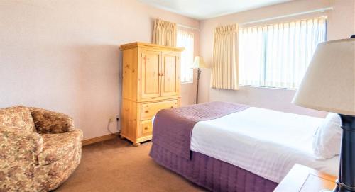 a hotel room with a bed and a chair at Lagonita Lodge in Big Bear Lake
