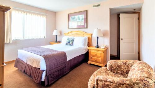 a hotel room with a bed and a chair at Lagonita Lodge in Big Bear Lake