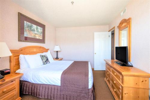 a bedroom with a bed and a flat screen tv at Lagonita Lodge in Big Bear Lake