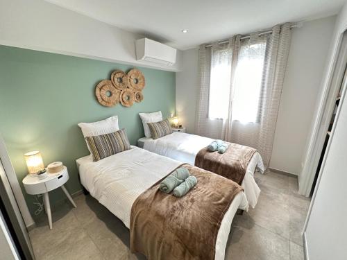 a bedroom with two beds and a mirror on the wall at T3 Neuf Garage, clim, wifi, plages à 3min à pied! in Collioure