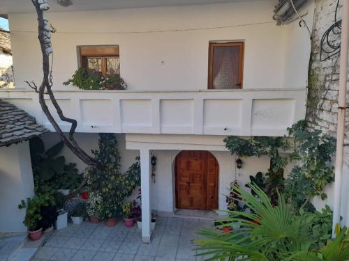 a house with a wooden door and a balcony at Sokolli Guest House in Gjirokastër