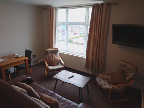 a living room with a couch and chairs and a window at Pier View Apartments by Pillow Partners in Skegness