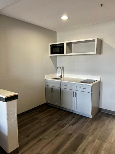 an empty kitchen with a sink and a microwave at Super 8 by Wyndham Sealy in Sealy