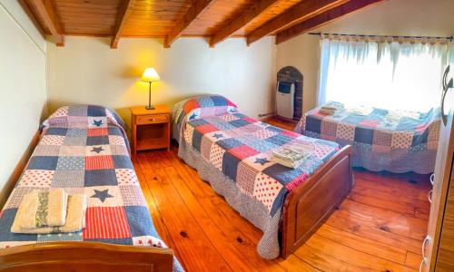 1 dormitorio con 2 camas en una habitación en Cabañas Posada de las Flores en Tolhuin