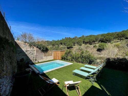 une cour avec une piscine et des chaises longues dans l'établissement Jardin de la Garrigue - Maison 160m2 - Piscine, à Aragon