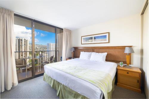 a hotel room with a bed and a balcony at Beautiful Mountain Views Condo, Parking is free! in Honolulu