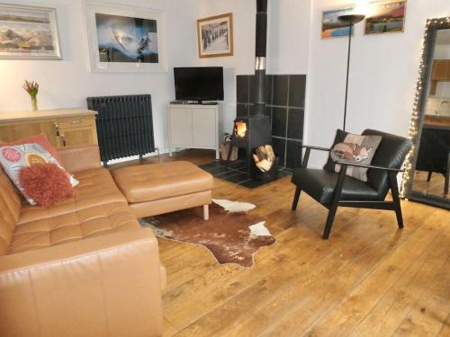 a living room with a couch and a chair at Baltinna West - by Where Stags Roar in Newtonmore