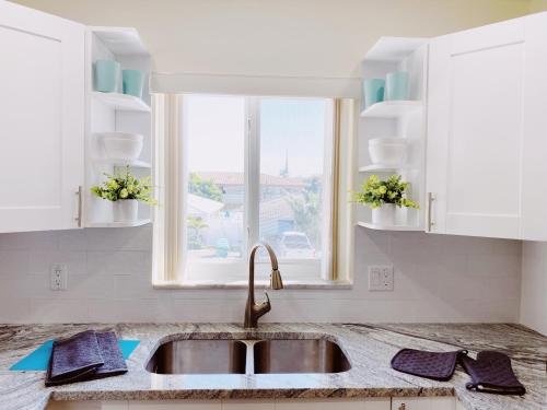 a kitchen with a sink and a window at Coco Palms Apartments By Lowkl in Lighthouse Point