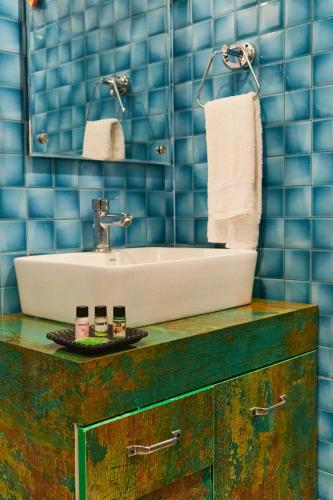 a bathroom with a sink and blue tiled walls at Rajaji Delight, Rajaji National Park, Rishikesh in Rishīkesh