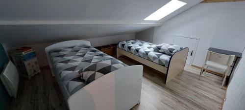 唐萊沃斯熱的住宿－charmant & relaxant F3，一间卧室配有两张床、一张桌子和一把椅子
