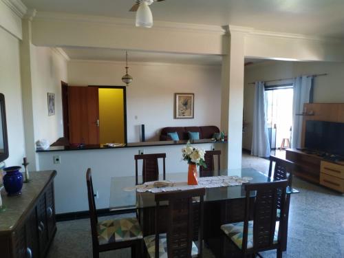 a dining room and living room with a table and chairs at Apartamento charmoso in Saquarema