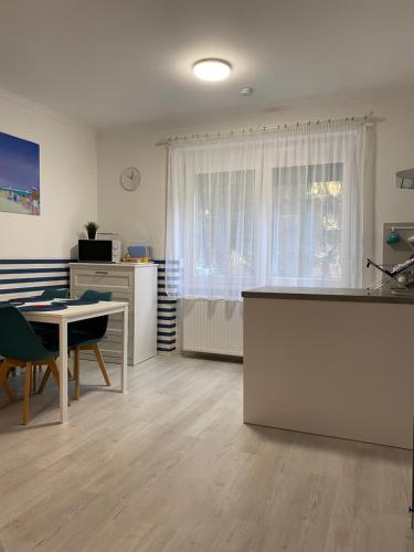 uma cozinha e sala de jantar com uma mesa e uma janela em City Center Apartman 2. Nagykanizsa em Nagykanizsa