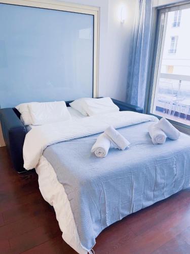 un grand lit avec deux serviettes dessus dans l'établissement Belle chambre Champs-Élysée, à Paris