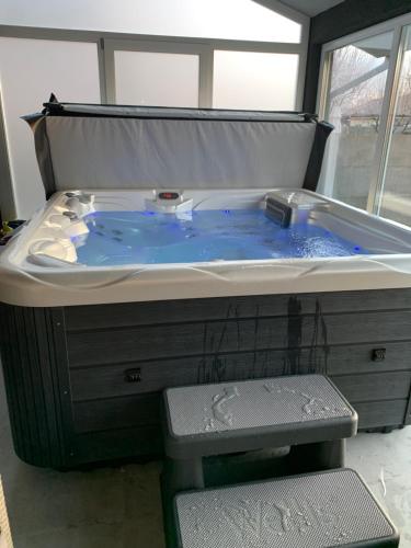 a jacuzzi tub with blue water in it at DUO Residence in Dumbrăviţa