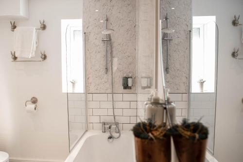 biała łazienka z wanną i prysznicem w obiekcie RiverTree House w mieście Llangollen
