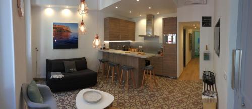 a kitchen and a living room with a couch and a table at Au Coeur de Cassis in Cassis