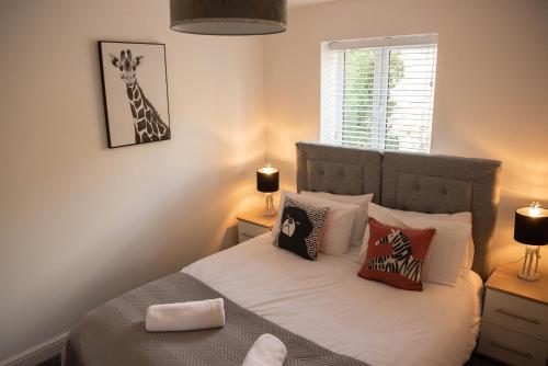 a bedroom with a bed with pillows and a giraffe picture at RiverTree House in Llangollen