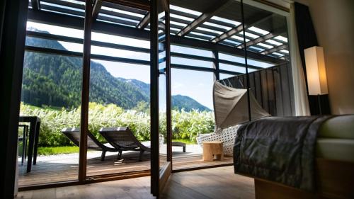 a bedroom with a balcony with a view of a mountain at La Casies Mountain Hotel in Santa Maddalena in Casies