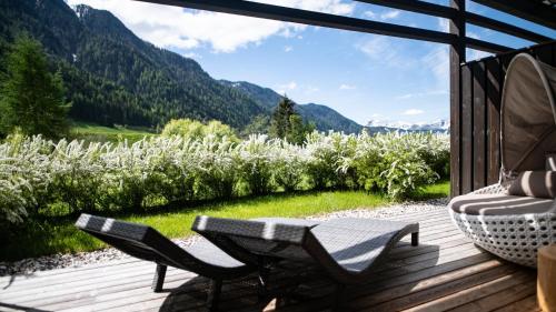 a porch with chairs and a view of a mountain at La Casies Mountain Hotel in Santa Maddalena in Casies