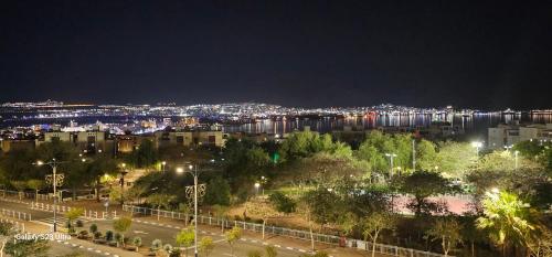 a night view of a city with a river and buildings at The suite in Eilat