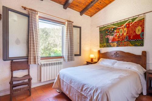 - une chambre avec un lit, une fenêtre et une chaise dans l'établissement Casa con piscina cerca de Girona, à Gérone