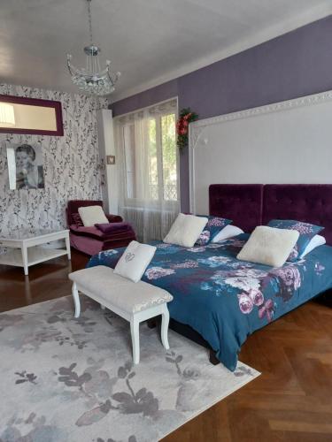 1 dormitorio con cama grande y pared morada en Ma promesse, en Vals-les-Bains