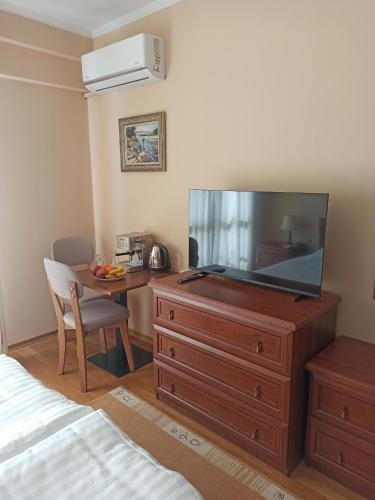 a bedroom with a dresser with a flat screen tv at Home Sweet Rental in Tirana
