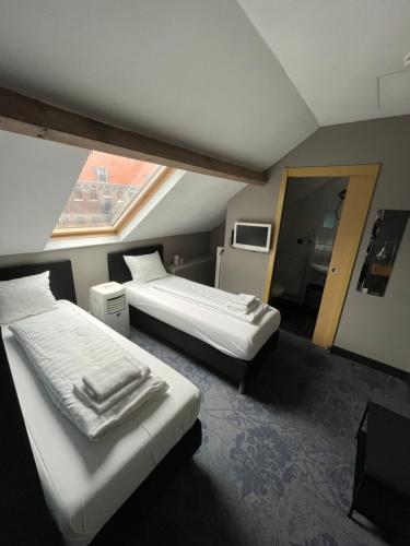 um quarto de hotel com duas camas e uma janela em Hotel Oostereiland em Hoorn