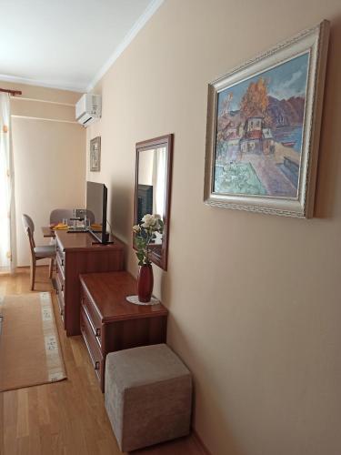 a living room with a desk and a painting on the wall at Home Sweet Rental in Tirana