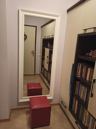 a hallway with a mirror and two red stools at Home Sweet Rental in Tirana
