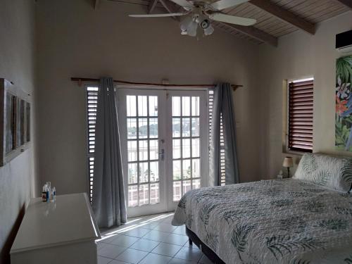 a bedroom with a bed and a ceiling fan at Seascape Villa 3BR with Stunning Caribbean Sea View in Castries