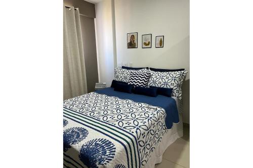 Schlafzimmer mit einem Bett mit blauer und weißer Bettwäsche in der Unterkunft Lindo apartamento, ao lado do Shopping Partage Nova Betânia Ed WHB in Mossoró