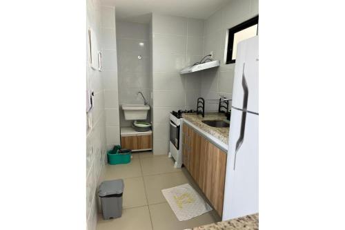 una pequeña cocina con fregadero y nevera. en Lindo apartamento, ao lado do Shopping Partage Nova Betânia Ed WHB, en Mossoró