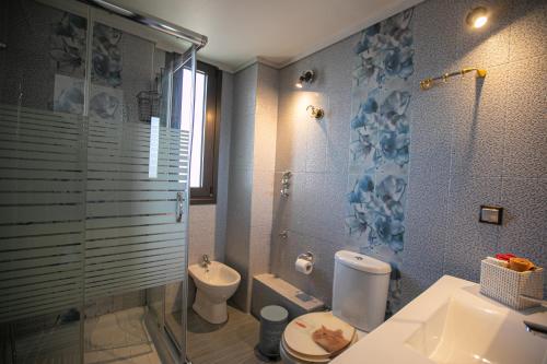 a bathroom with a shower and a toilet and a sink at Stunning city view apt & parking space at Old town in Thessaloniki